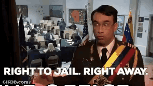 A Man In A Military Uniform Is Standing In Front Of A Group Of People In A Room . GIF
