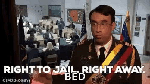 A Man In A Military Uniform Is Standing In Front Of A Group Of People In An Office . GIF