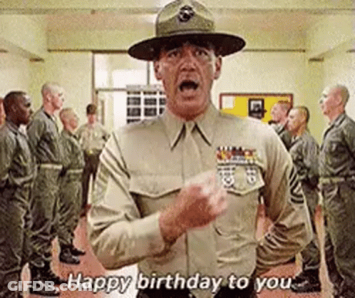 A Man In A Military Uniform Is Standing In Front Of A Group Of Soldiers And Saying Happy Birthday To You . GIF