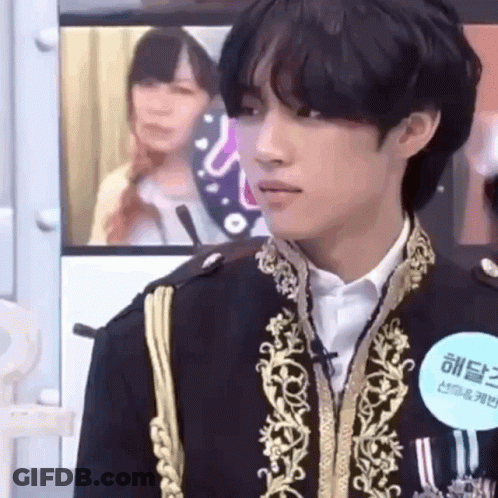 A Man In A Military Uniform Is Standing In Front Of A Microphone . GIF