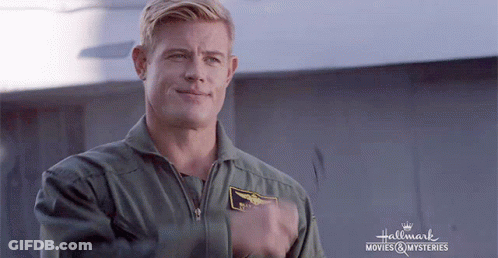 A Man In A Military Uniform Is Standing In Front Of A Sign That Says Hallmark Movies & Mysteries . GIF