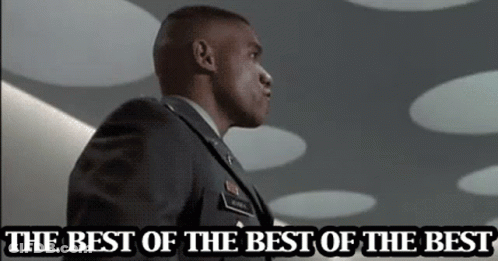 A Man In A Military Uniform Is Standing In Front Of A Sign That Says The Best Of The Best GIF