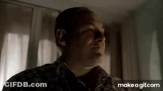 A Man In A Military Uniform Is Standing In Front Of A Window In A Room . GIF