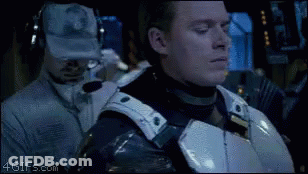 A Man In A Military Uniform Is Standing Next To Another Man Wearing Headphones And A Hat With A Military Logo On It GIF