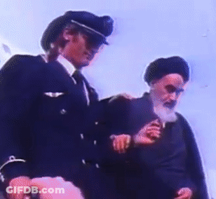 A Man In A Military Uniform Is Standing Next To Another Man With A Beard GIF