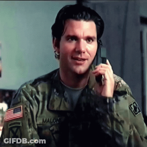 A Man In A Military Uniform Is Talking On A Cell Phone With Malon Written On His Sleeve GIF