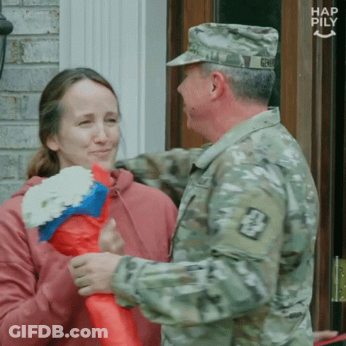 Man In Military Uniform Talking To Woman With Flowers GIF