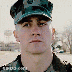 A Man In A Military Uniform Is Wearing A Hat That Says Marines On It GIF
