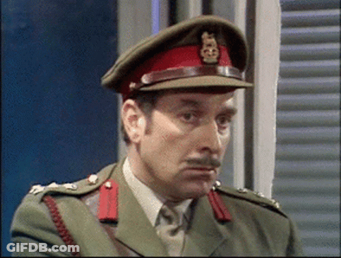 A Man In A Military Uniform Is Wearing A Red Hat With A Gold Emblem On It GIF