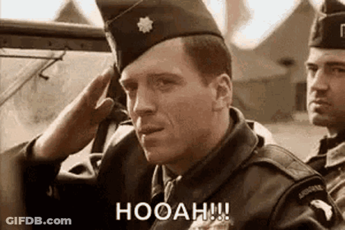 A Man In A Military Uniform Salutes While Another Man Looks On . GIF
