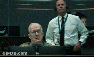 A Man In A Military Uniform Sits In Front Of A Computer Screen GIF