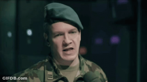 A Man In A Military Uniform Speaking Into A Microphone With The Word Sur In The Background GIF