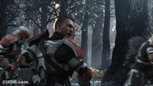 A Man In A Military Uniform Stands In A Forest GIF