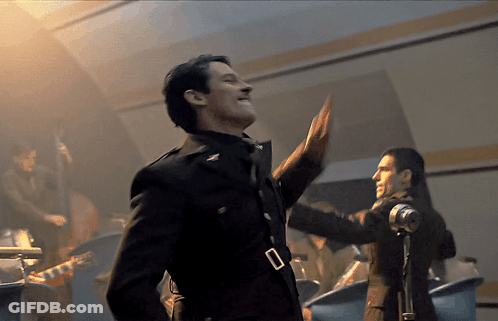 A Man In A Military Uniform Stands In Front Of A Band GIF