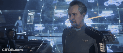 A Man In A Military Uniform Stands In Front Of A Computer Screen GIF