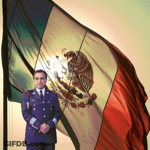 A Man In A Military Uniform Stands In Front Of A Mexican Flag With An Eagle On It GIF