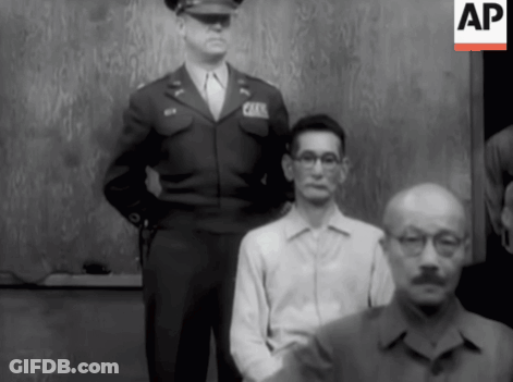 A Man In A Military Uniform Stands Next To A Man In A White Shirt With Glasses GIF