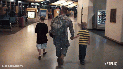 A Man In A Military Uniform Walks With Two Young Boys GIF