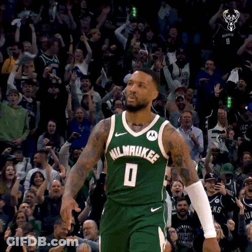 A Man In A Milwaukee Jersey Stands In Front Of A Crowd Of People GIF