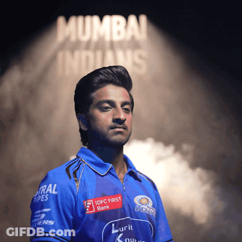 A Man In A Mumbai Indians Shirt Stands In Front Of A Sign That Says Mumbai Indians GIF
