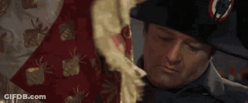 A Man In A Napoleon Hat Is Holding A Red And White Blanket . GIF