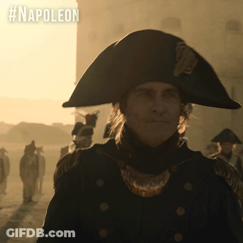 A Man In A Napoleon Hat Is Standing In Front Of A Building GIF