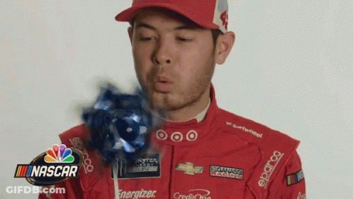 A Man In A Nascar Uniform Is Blowing A Blue Lollipop GIF