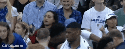 A Man In A Nc Place Shirt Is Standing In The Crowd GIF