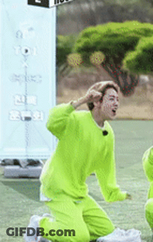 A Man In A Neon Green Outfit Is Kneeling On The Ground GIF