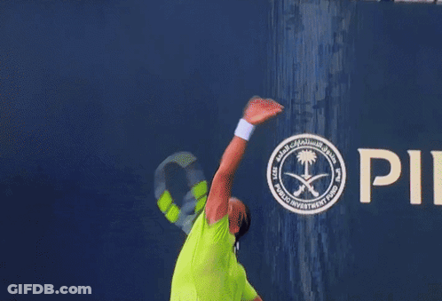 A Man In A Neon Green Shirt Is Playing Tennis GIF