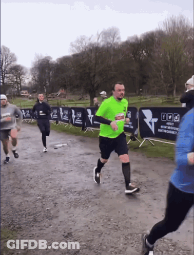 A Man In A Neon Green Shirt Is Running In Front Of A Banner That Says #Test GIF