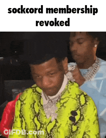 A Man In A Neon Green Snakeskin Jacket Is Being Adjusted By Another Man GIF