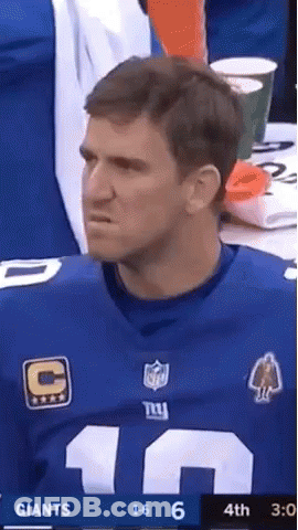 A Man In A New York Giants Jersey Is Watching A Football Game GIF
