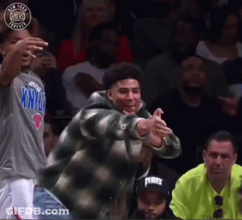 A Man In A New York Knicks Shirt Is Dancing In A Crowd GIF