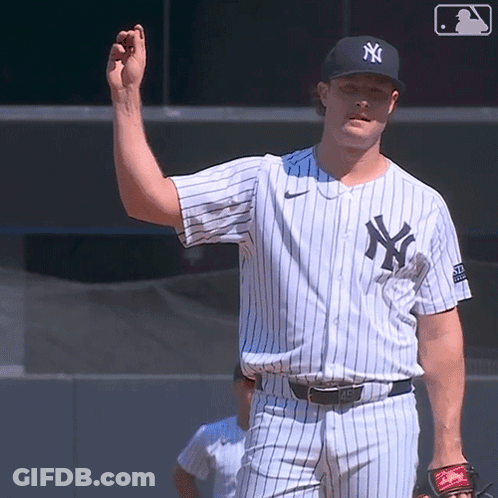 A Man In A New York Yankees Jersey Holds His Hand Up GIF