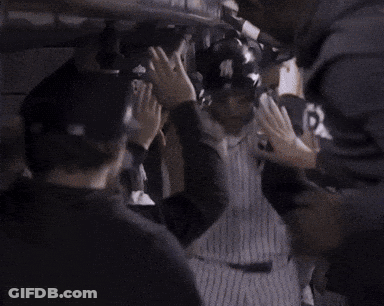 A Man In A New York Yankees Jersey Is Being Congratulated By His Teammates GIF