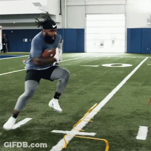 A Man In A Nike Headband Runs With A Football GIF