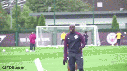 A Man In A Nike Shirt Is Standing On A Soccer Field GIF
