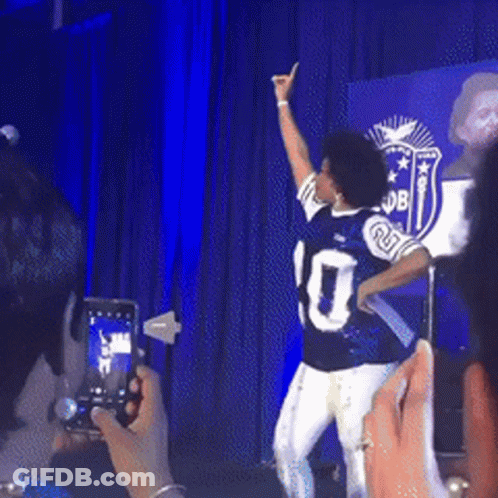 A Man In A Number 10 Jersey Is Dancing On Stage GIF