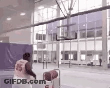 A Man In A Number 15 Jersey Is Playing Basketball On A Court . GIF