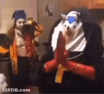 A Man In A Nun Costume Is Holding A Gun Next To A Woman In A Costume . GIF