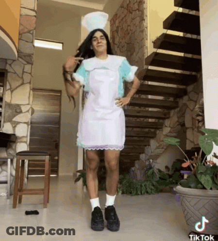 A Man In A Nurse Costume Is Standing In Front Of Stairs GIF