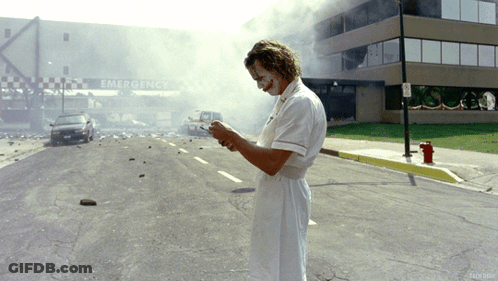 A Man In A Nurse 'S Uniform Is Standing In Front Of An Emergency Entrance GIF