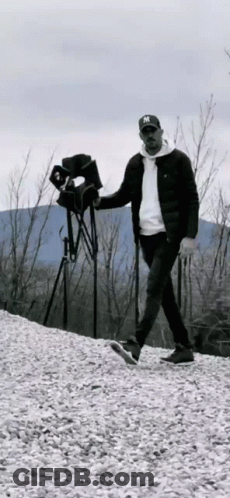 A Man In A Ny Hat Is Walking On A Pile Of Gravel . GIF
