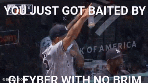 A Man In A Ny Yankees Jersey Is Holding A Bottle Of Beer While Standing In A Dugout . GIF