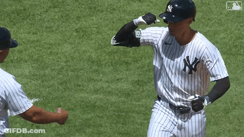 A Man In A Ny Yankees Uniform Is Giving A Fist Bump To Another Man GIF