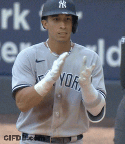 A Man In A Ny Yankees Uniform Stands On The Field GIF
