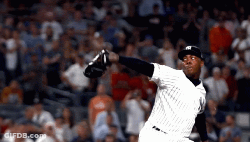 A Man In A Ny Yankees Uniform Throws A Ball GIF