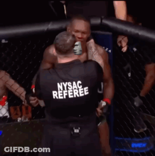 A Man In A Nysac Referee Shirt Stands In Front Of A Cage GIF