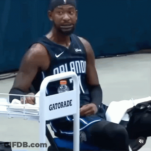A Man In A Orlando Jersey Sits In A Chair With A Gatorade Bottle GIF